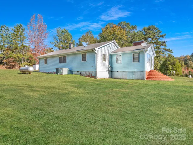 a front view of house with yard and trees in the background