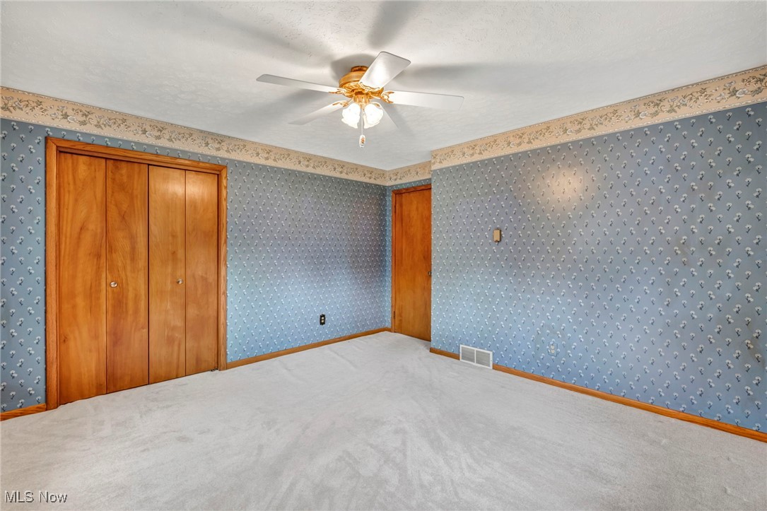 9184 Zimmerman Road Homerville, OH 44235 - Photo 21 of 50 Unfurnished bedroom featuring light carpet, a closet, a textured ceiling, and ceiling fan