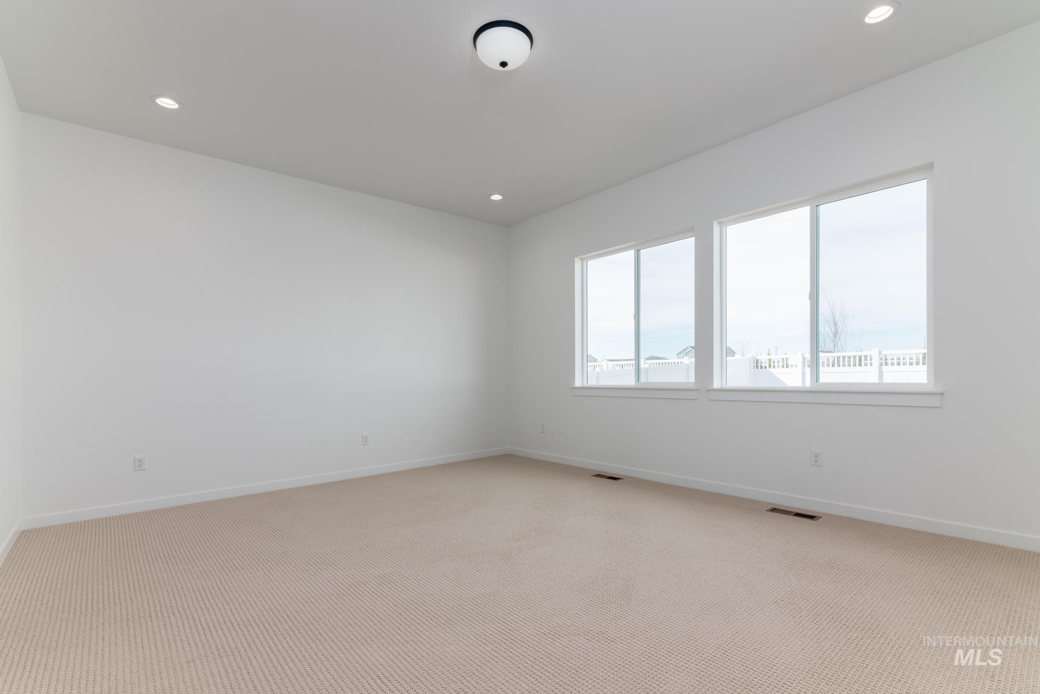 8459 South Country Wind Avenue Meridian, ID 83642 - Photo 8 of 11 Carpeted empty room featuring baseboards and recessed lighting