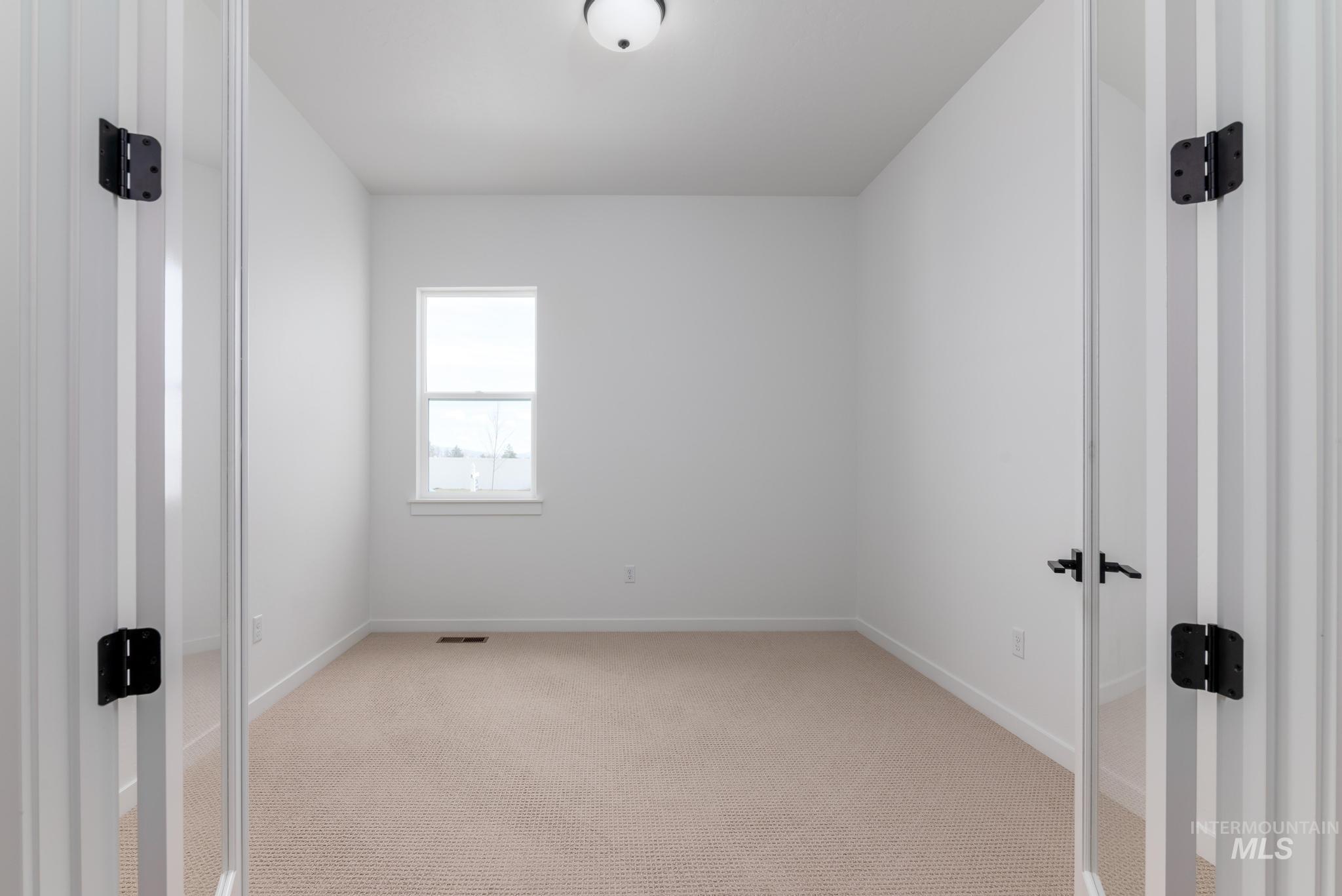 8459 South Country Wind Avenue Meridian, ID 83642 - Photo 10 of 11 Empty room featuring light colored carpet and baseboards