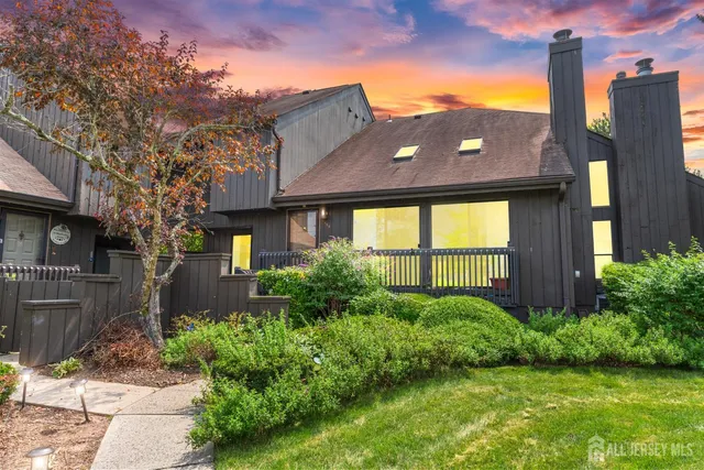 a brick house next to a yard with potted plants