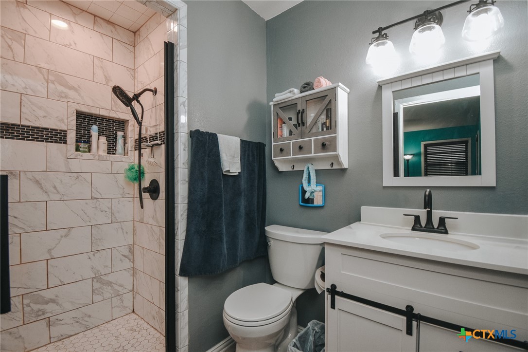 3308 Erwin Avenue Victoria, TX 77901 - Photo 12 of 16 a bathroom with a toilet a sink and mirror