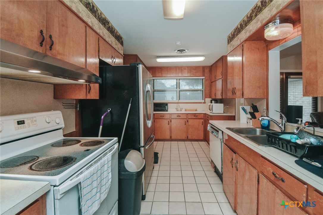 3308 Erwin Avenue Victoria, TX 77901 - Photo 9 of 16 a kitchen that has a sink stainless steel appliances a counter space and a window