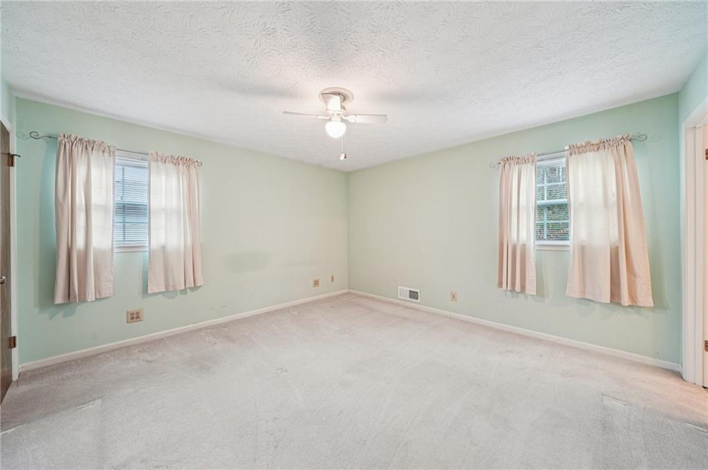 1315 Sanden Ferry Drive Decatur, GA 30033 - Photo 13 of 33 an empty room with chandelier fan and windows