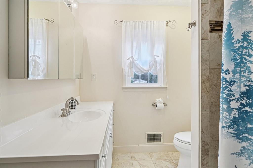 1315 Sanden Ferry Drive Decatur, GA 30033 - Photo 19 of 33 a bathroom with a sink a toilet and shower curtain