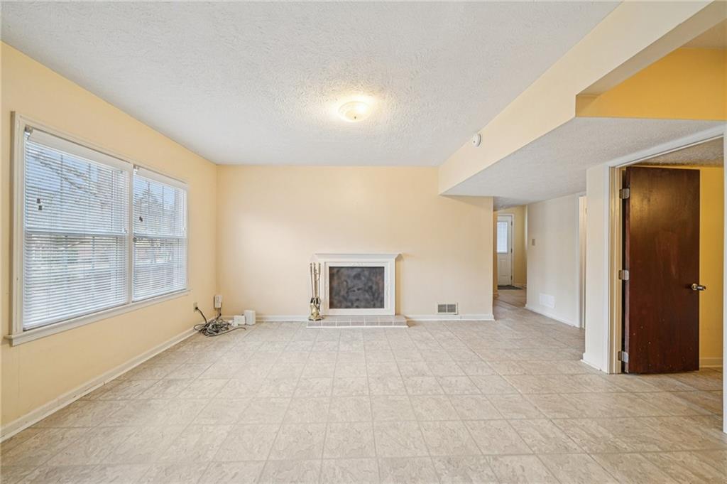 1315 Sanden Ferry Drive Decatur, GA 30033 - Photo 21 of 33 an empty room with a fireplace and a large window