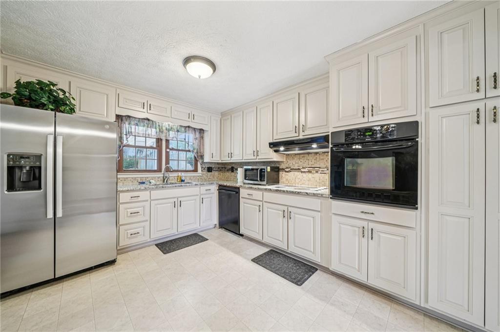1315 Sanden Ferry Drive Decatur, GA 30033 - Photo 10 of 33 a kitchen with white cabinets and white appliances