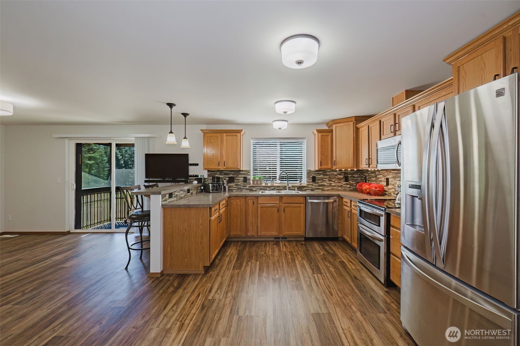 13818 Glenwood Road Southwest Port Orchard, WA 98367 - Photo 11 of 40 a kitchen with a refrigerator cabinets and wooden floor