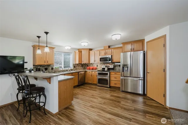 a kitchen with kitchen island granite countertop stainless steel appliances and wooden cabinets