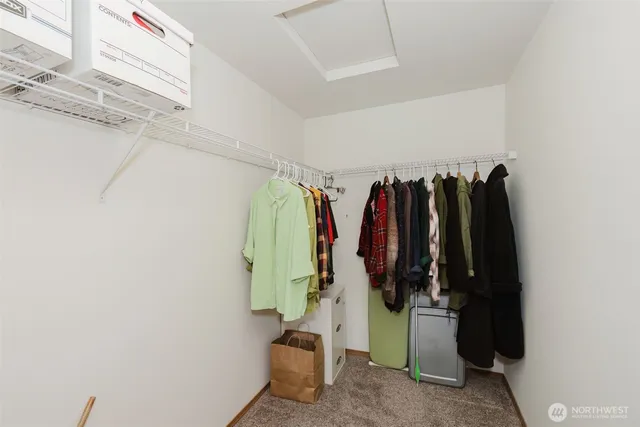 a view of walk in closet with clothes and shoes