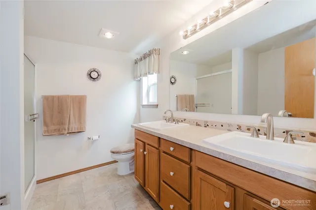 a spacious bathroom with a double vanity sink mirror and toilet