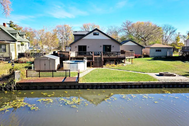 a view of a house with pool lawn chairs and a yard with swimming pool