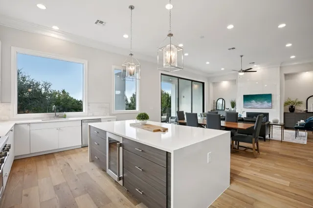 a large kitchen with kitchen island a sink table and chairs