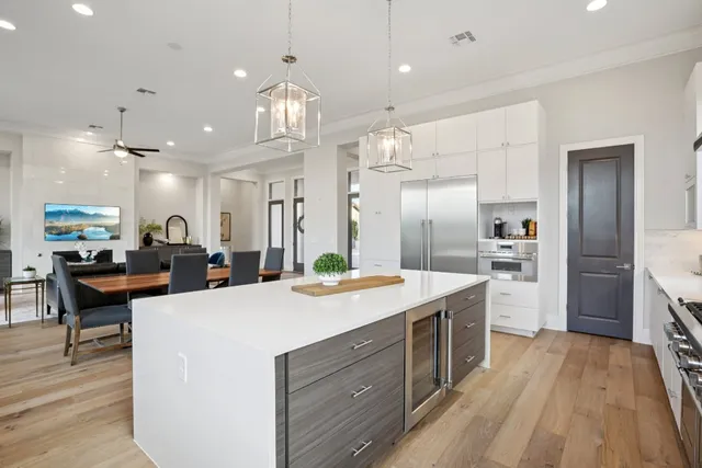 a large kitchen with kitchen island a large island a sink stainless steel appliances and cabinets
