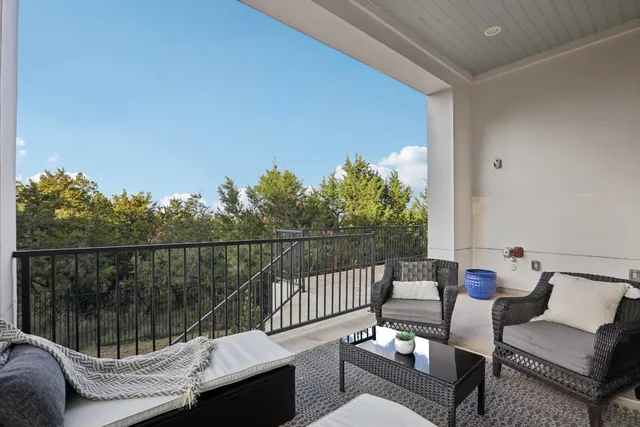 a view of a balcony with two chairs and a potted plant