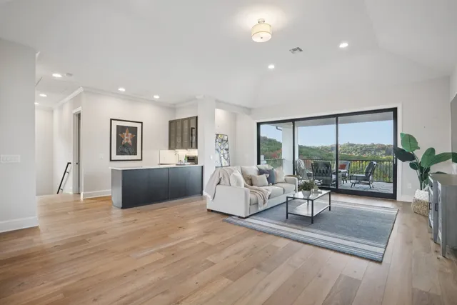 a living room with furniture large window and a table
