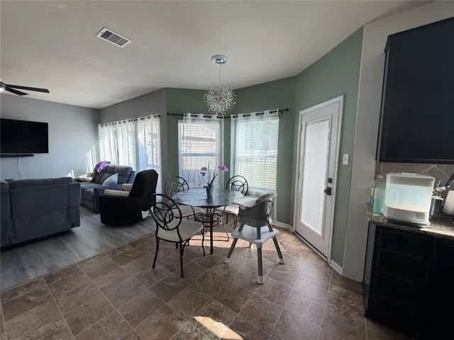 a living room with furniture a flat screen tv and a refrigerator