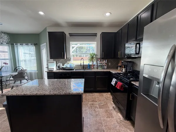 a kitchen with a sink refrigerator and microwave