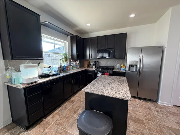 a kitchen with a sink refrigerator and cabinets