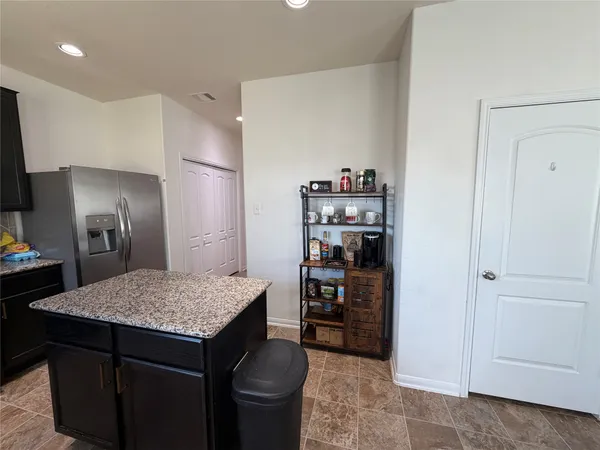 a kitchen with refrigerator and cabinets