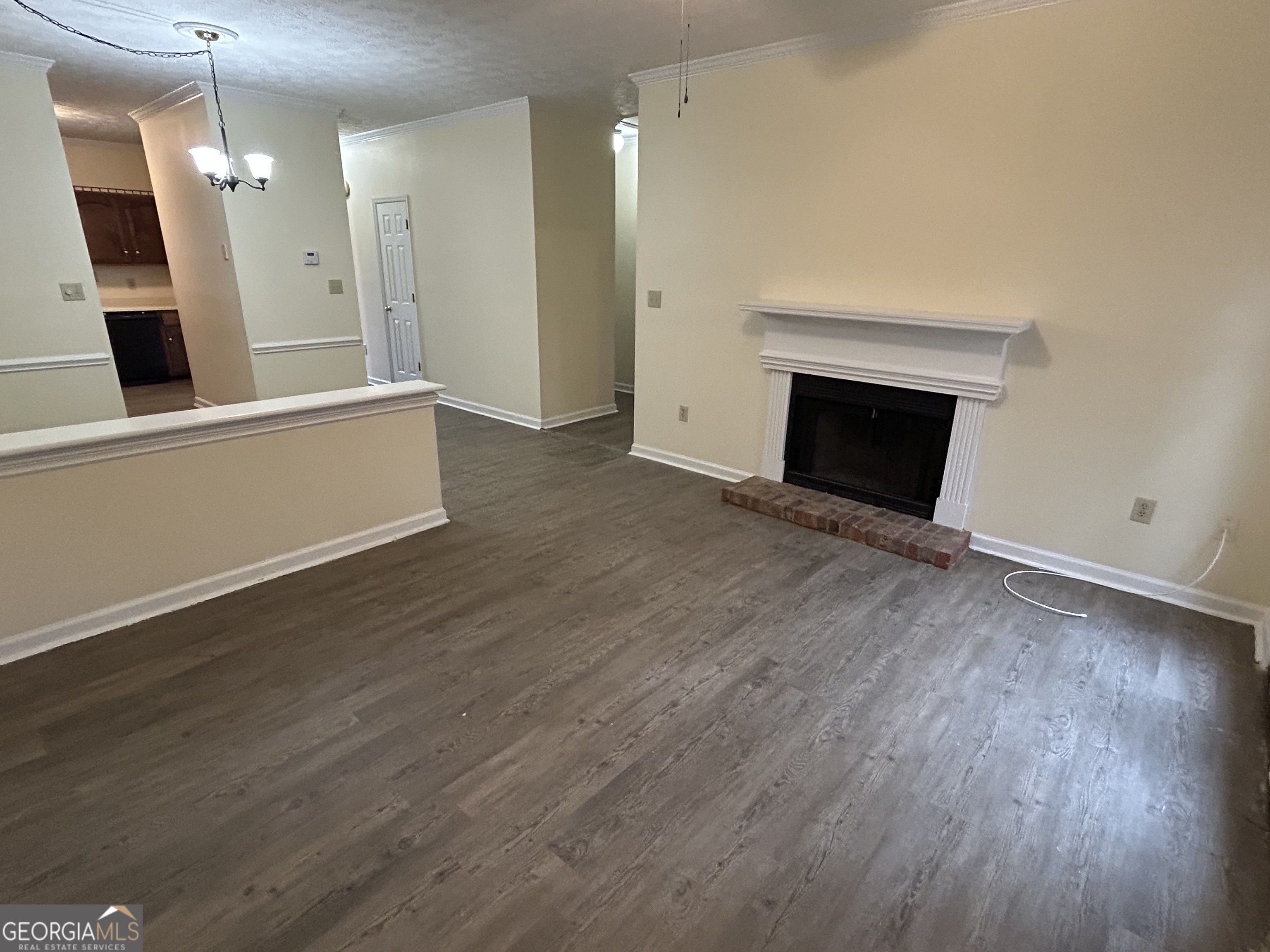 250 Cleveland Road, Unit 219 Bogart, GA 30622 - Photo 7 of 20 an empty room with wooden floor and fireplace