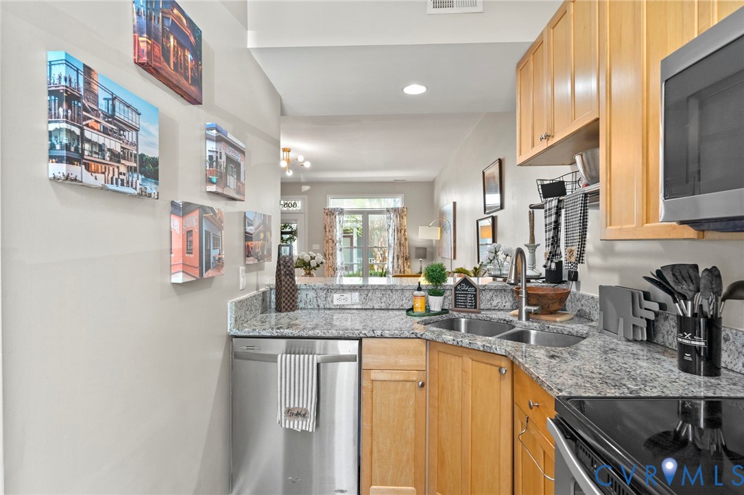 605 Spring Street, Unit B Richmond, VA 23220 - Photo 11 of 42 a kitchen with stainless steel appliances granite countertop a sink and a refrigerator