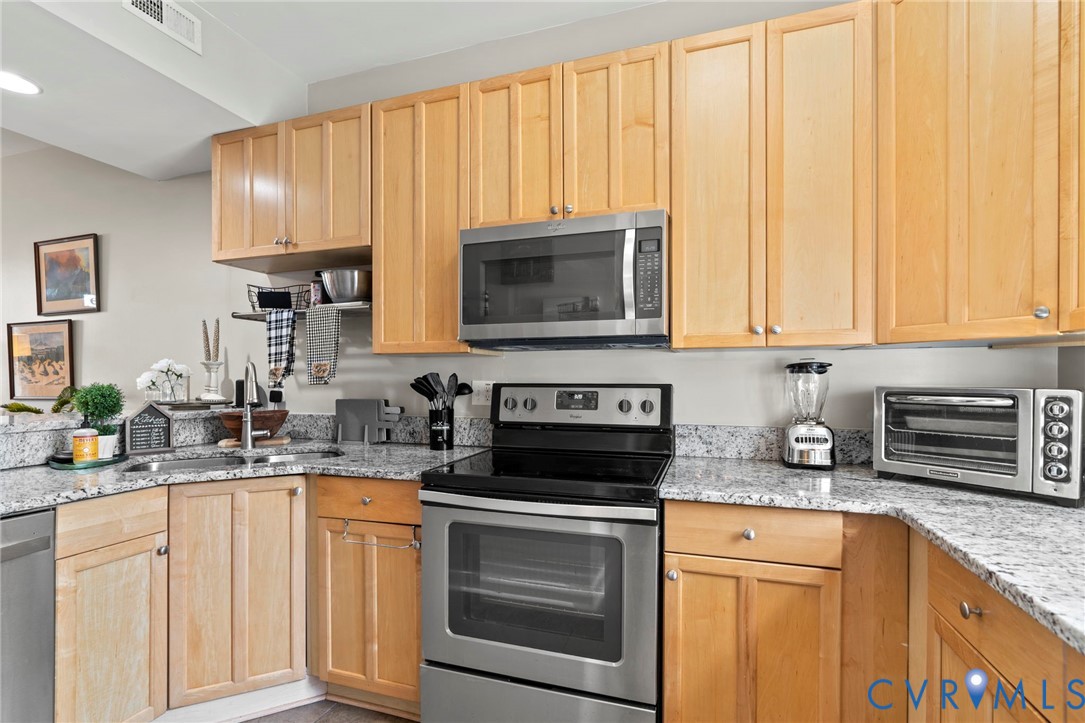 605 Spring Street, Unit B Richmond, VA 23220 - Photo 10 of 42 a kitchen with granite countertop white cabinets and stainless steel appliances