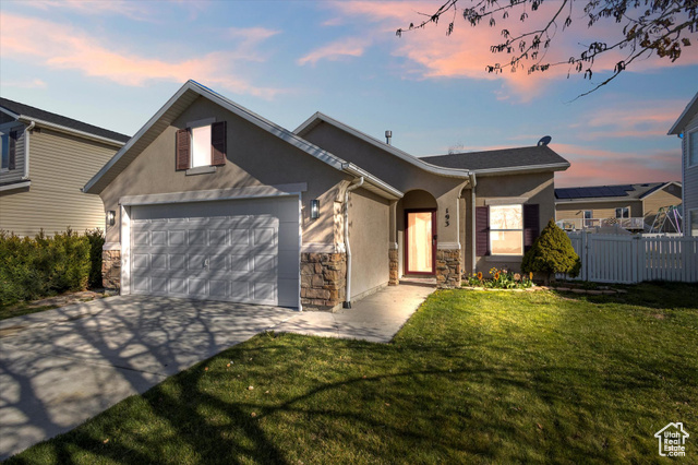Undisclosed Address Tooele, UT 84074 - Photo 1 of 1 Single story home featuring concrete driveway, stucco siding, stone siding, a front lawn, and fence