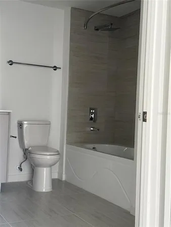a bathroom with a white toilet and a bathtub