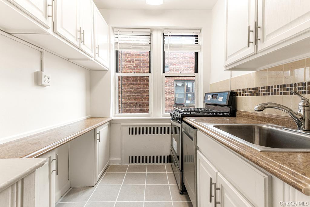 100-10 67th Road, Unit 6L Queens, NY 11375 - Photo 10 of 26 a kitchen with a sink and a refrigerator