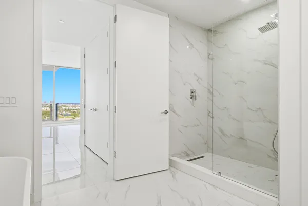 a view of a balcony with chairs and white walls