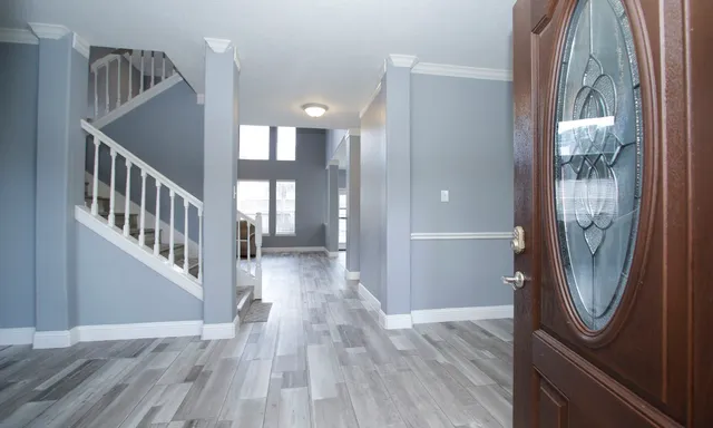a view of a hallway with wooden floor and entryway