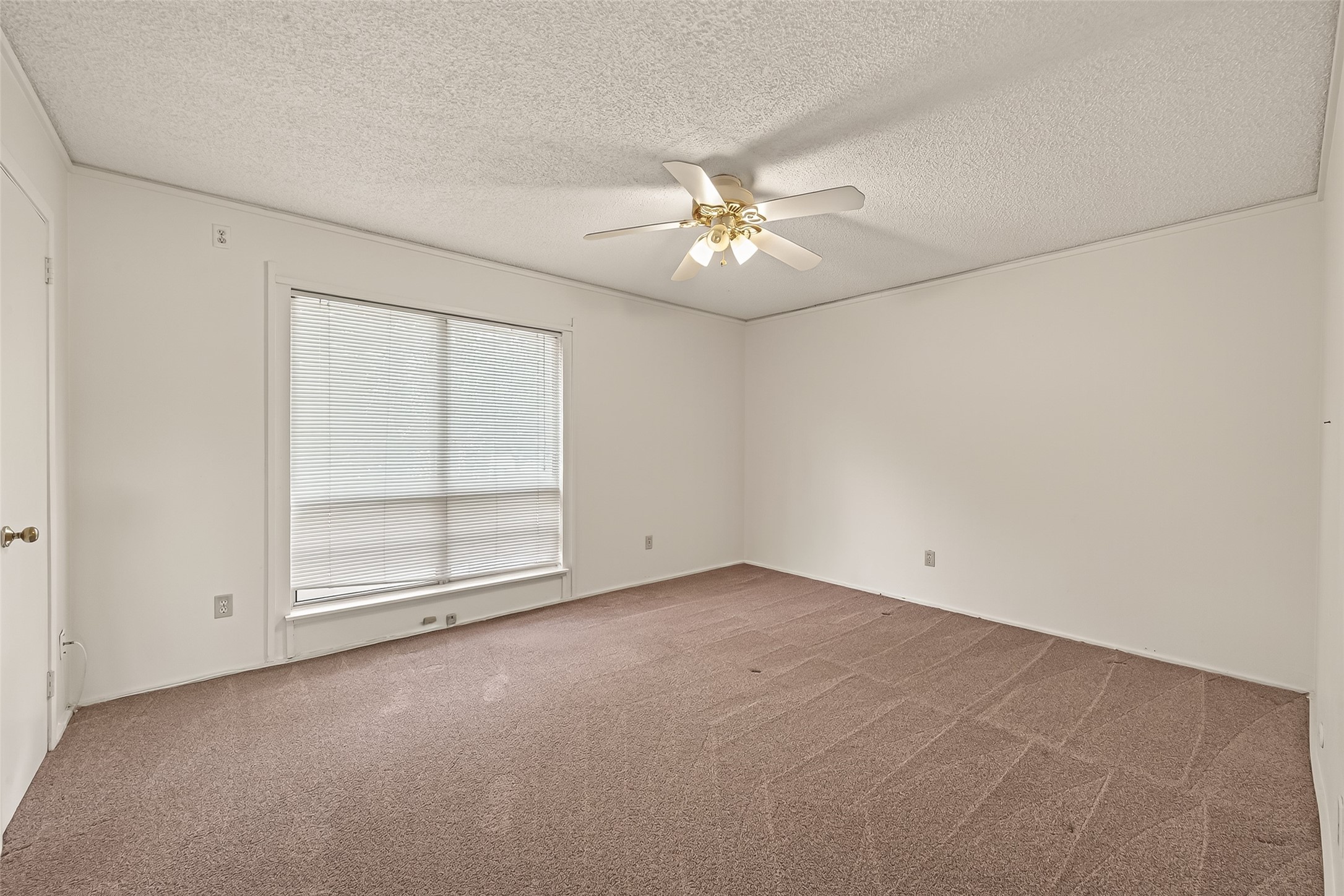 8211 Katy Freeway, Unit 19 Houston, TX 77024 - Photo 18 of 39 an empty room with chandelier fan and windows