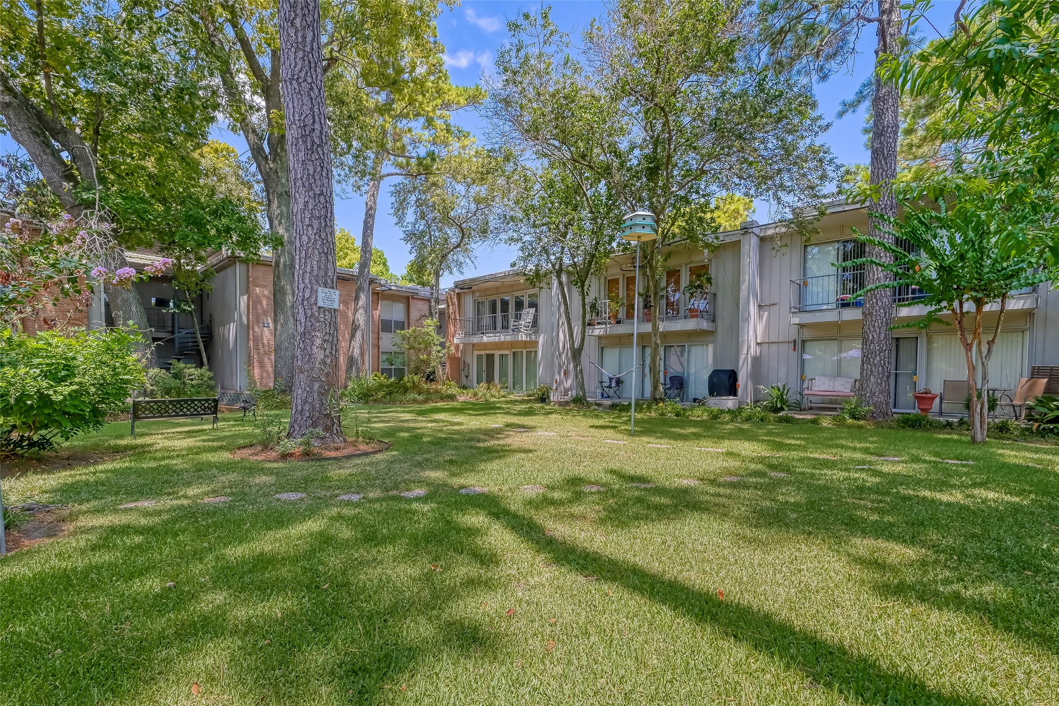8211 Katy Freeway, Unit 19 Houston, TX 77024 - Photo 32 of 39 a backyard of a house with lots of green space and fountain
