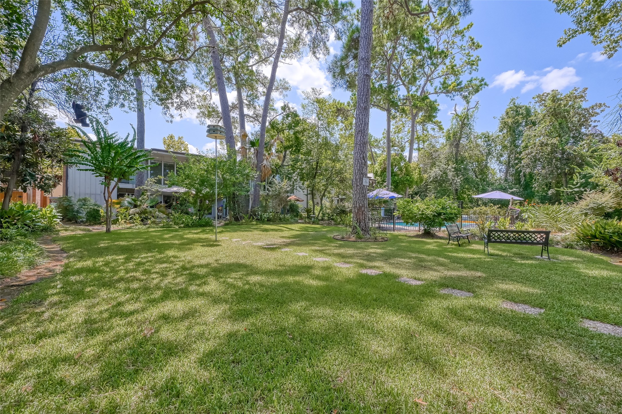 8211 Katy Freeway, Unit 19 Houston, TX 77024 - Photo 35 of 39 a backyard of a house with lots of green space and fountain
