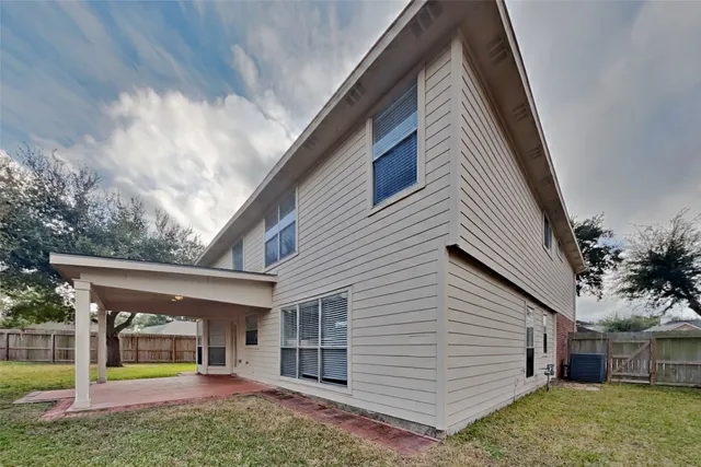 a view of a house with backyard and a tree