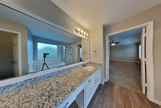 a bathroom with a granite countertop sink and a mirror