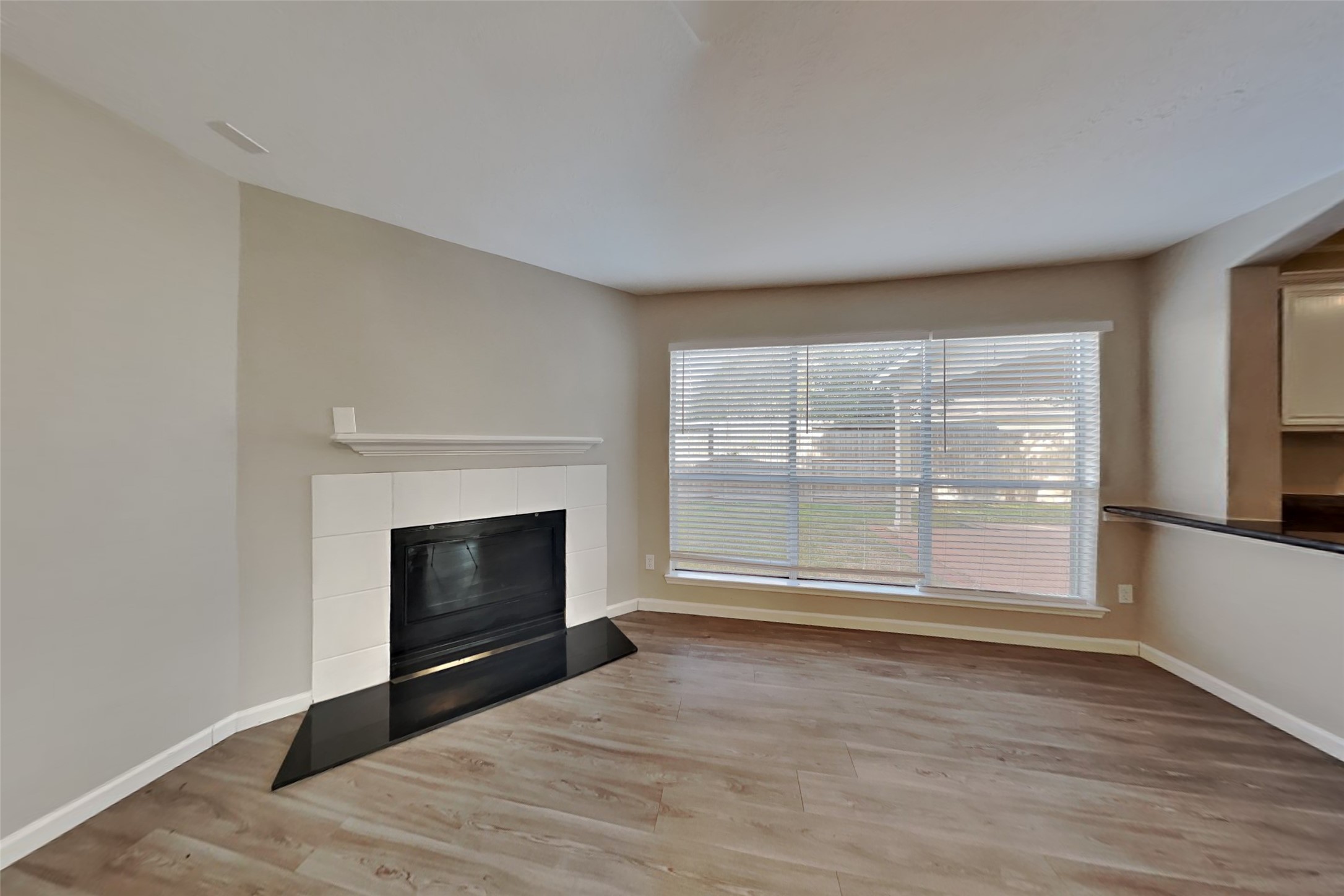 14706 Trailbrook Drive Houston, TX 77095 - Photo 2 of 23 a view of empty room with wooden floor and fireplace