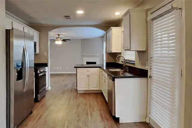 a kitchen with stainless steel appliances a sink stove and refrigerator