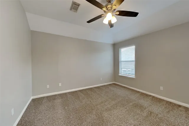 an empty room with a window and a fan