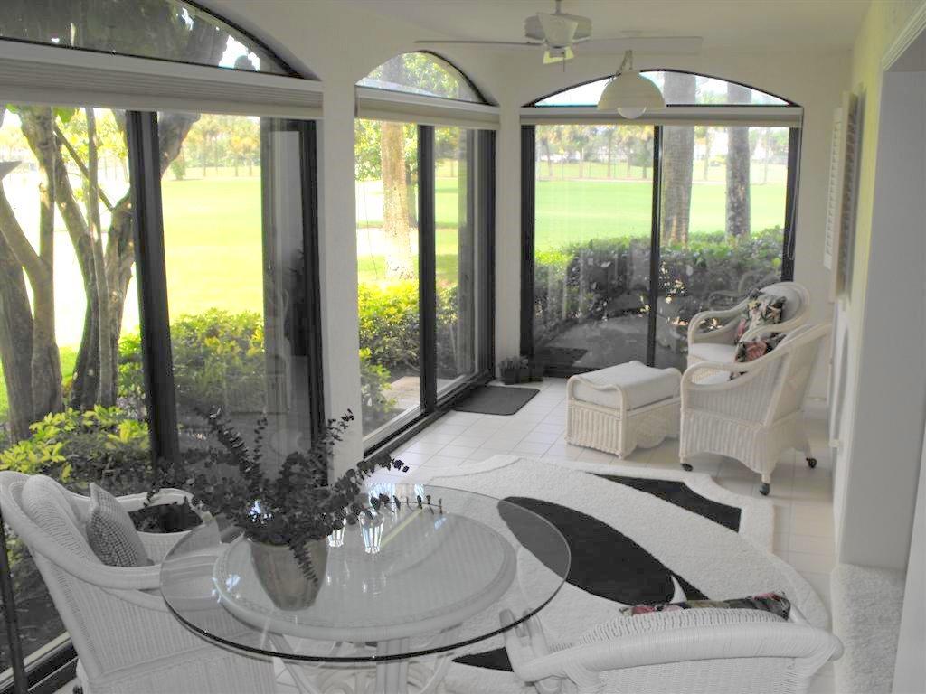 16622 Traders Crossing North, Unit 103 Jupiter, FL 33477 - Photo 1 of 14 a living room with patio furniture and a potted plant