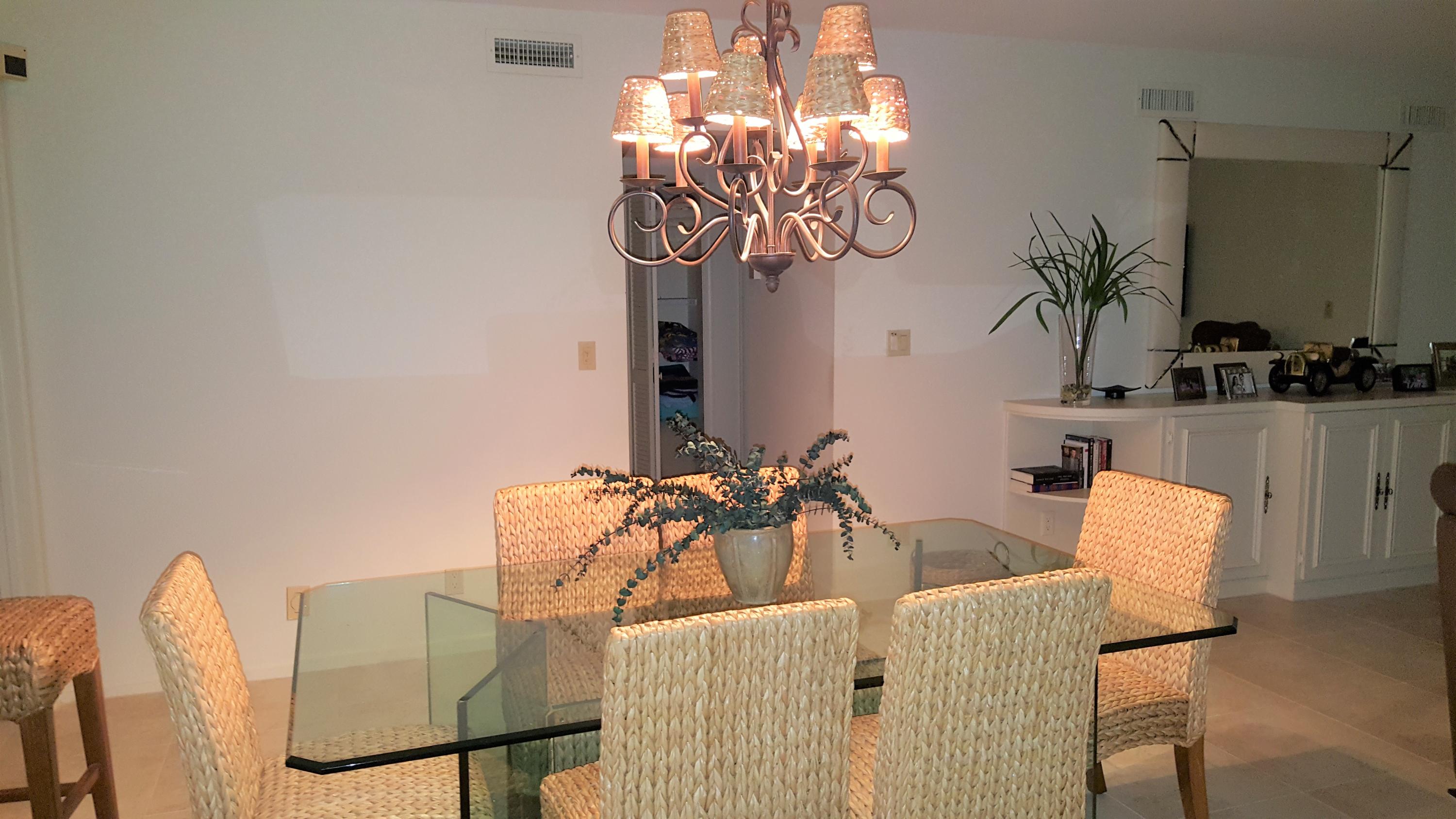 16622 Traders Crossing North, Unit 103 Jupiter, FL 33477 - Photo 3 of 14 a view of a dining room with furniture and chandelier
