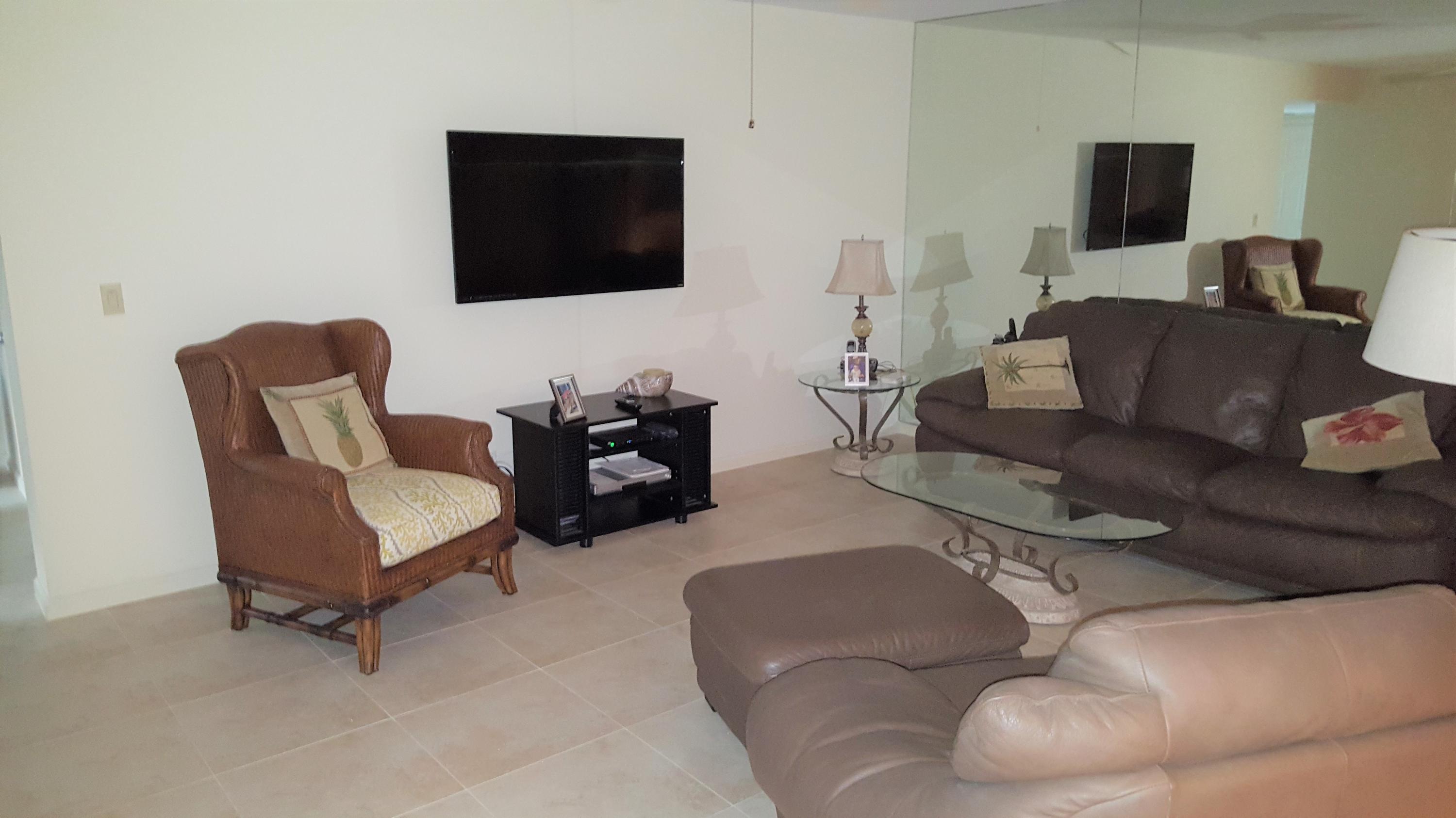 16622 Traders Crossing North, Unit 103 Jupiter, FL 33477 - Photo 4 of 14 a living room with furniture and a flat screen tv