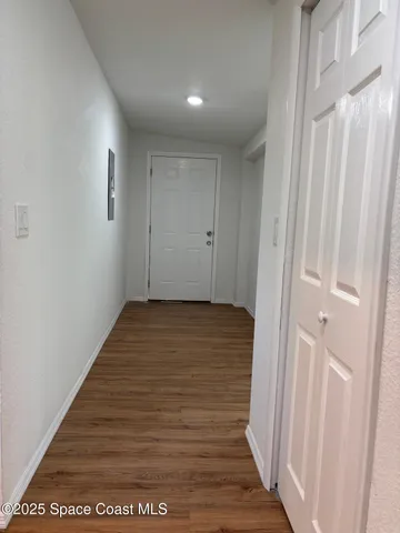 a view of a hallway with wooden floor