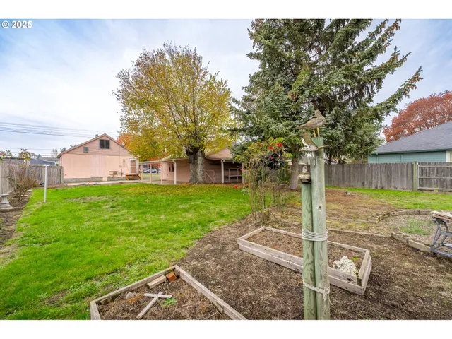 a view of a house with backyard and a tree