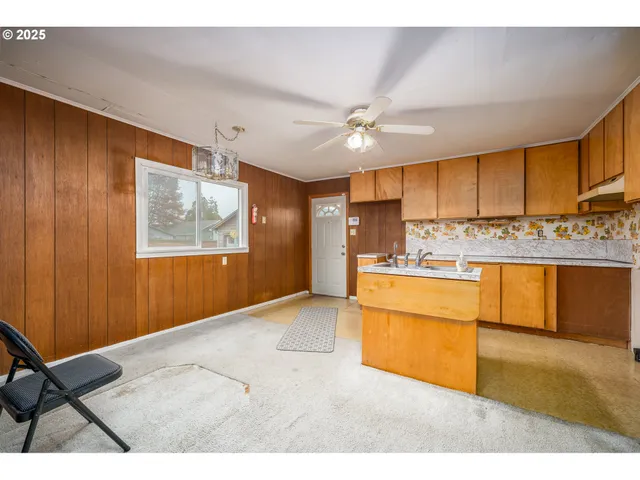 a kitchen with stainless steel appliances kitchen island granite countertop a refrigerator stove oven with white cabinets and wooden floor