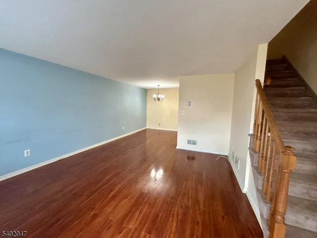 a view of a room with wooden floor and staircase