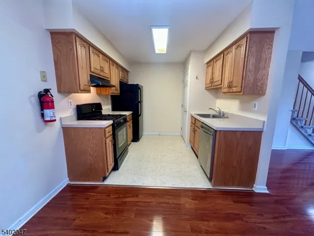 a view of a kitchen with fridge and wooden floor