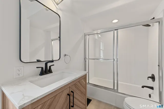 a bathroom with a sink a toilet and shower