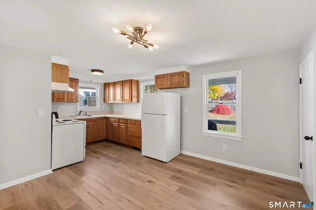 a kitchen with stainless steel appliances a lot of white cabinets and wooden floor